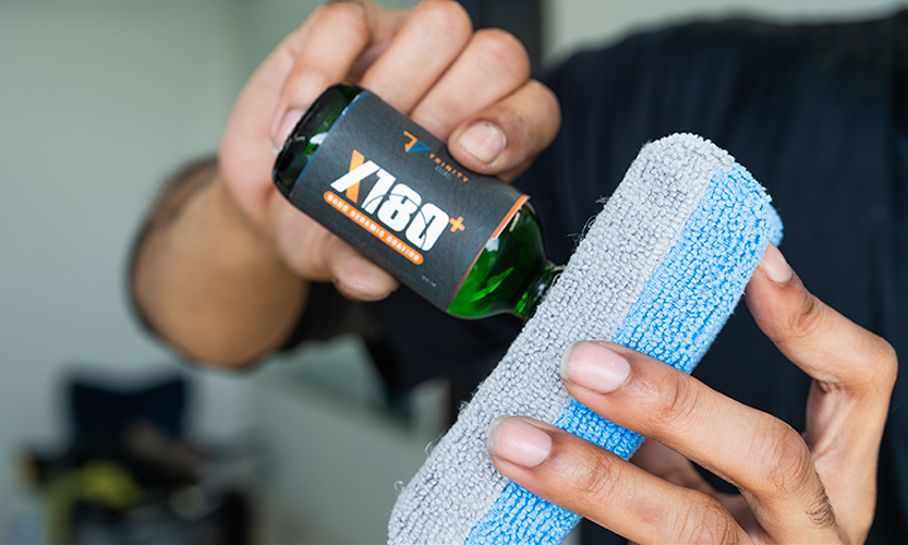 Applying Trinity Global X180+ ceramic coating to microfiber applicator at Prestige Auto Appearance