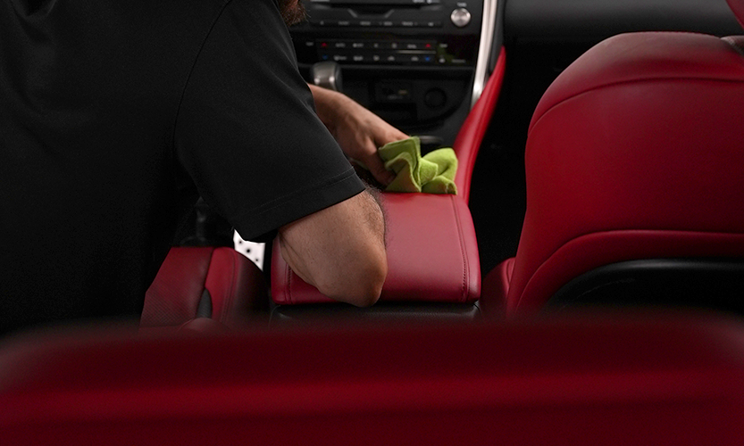 Applying ceramic interior coating to red leather console in luxury vehicle at Prestige Auto Appearance Allentown PA