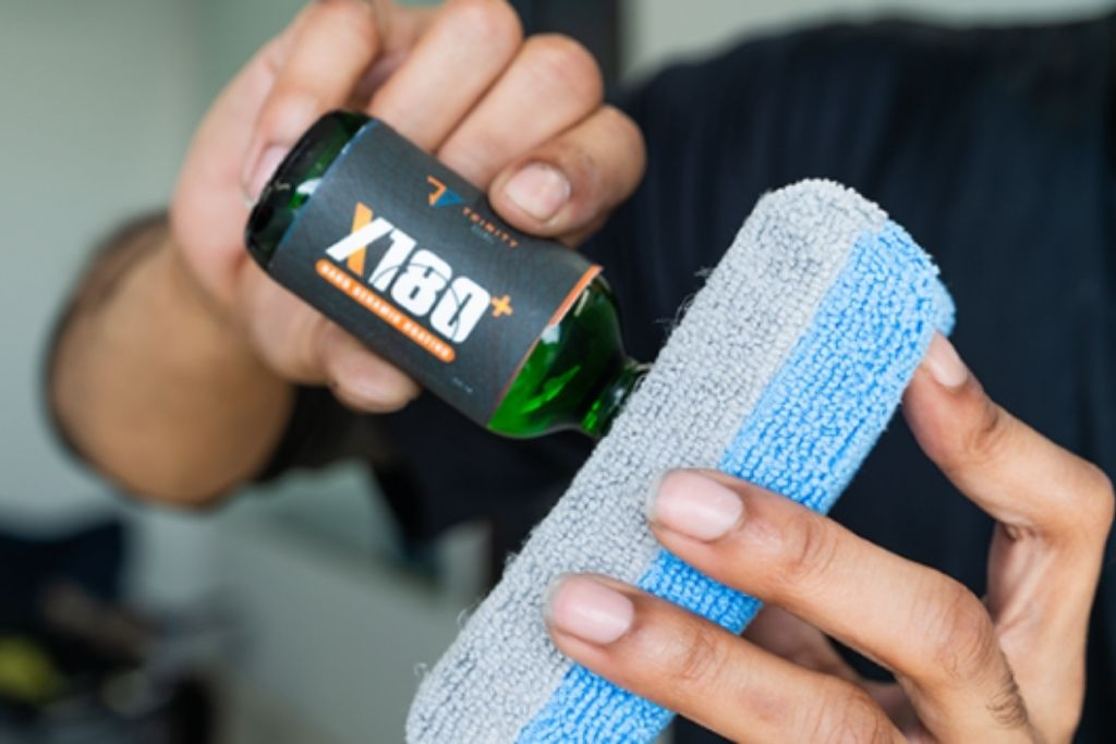 Prestige Auto Appearance expert pouring ceramic coating onto an applicator pad before treatment.