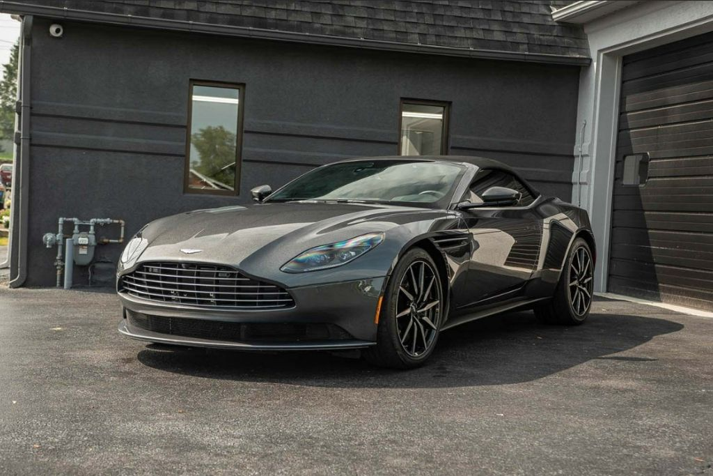 A sleek gray luxury sports car with a glossy finish parked outside Prestige Auto Appearance’s detailing shop.