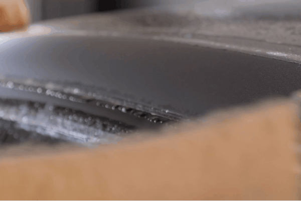 Close-up of UV-stable paint protection film being applied carefully to a car surface.