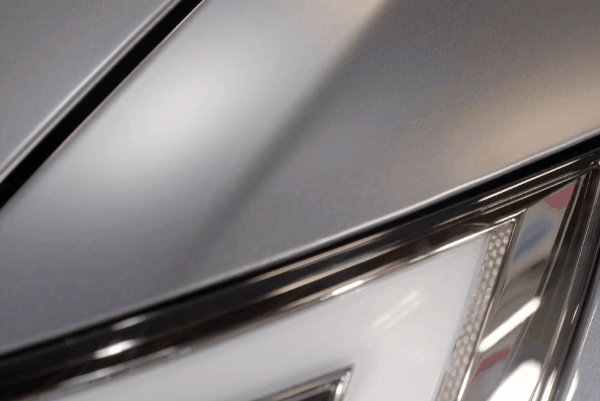 Close-up of a car hood and headlight protected with paint protection film (PPF).