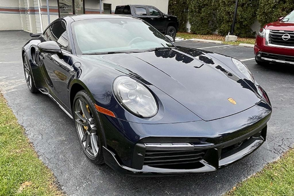 Polished black Porsche 911 Turbo S parked outside after detailing by Prestige Auto Appearance.