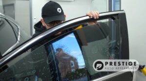 Technician installing window tint on a car door at Prestige Auto Appearance in Allentown, PA.