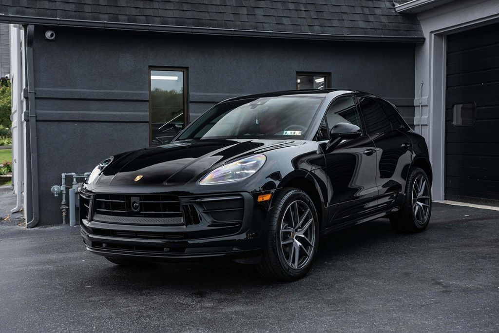Black luxury SUV with professionally tinted windows parked outside an automotive appearance shop.
