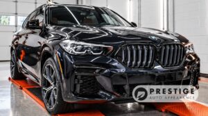 Black BMW SUV with glossy paint inside Prestige Auto Appearance's detailing studio in Allentown, PA.