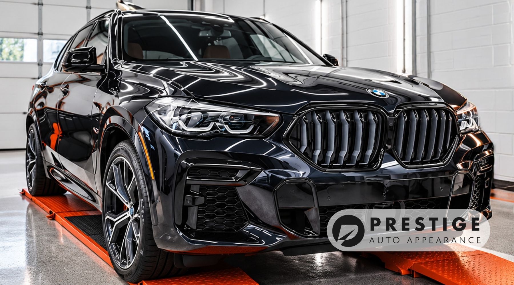 Black BMW SUV with glossy paint inside Prestige Auto Appearance's detailing studio in Allentown, PA.